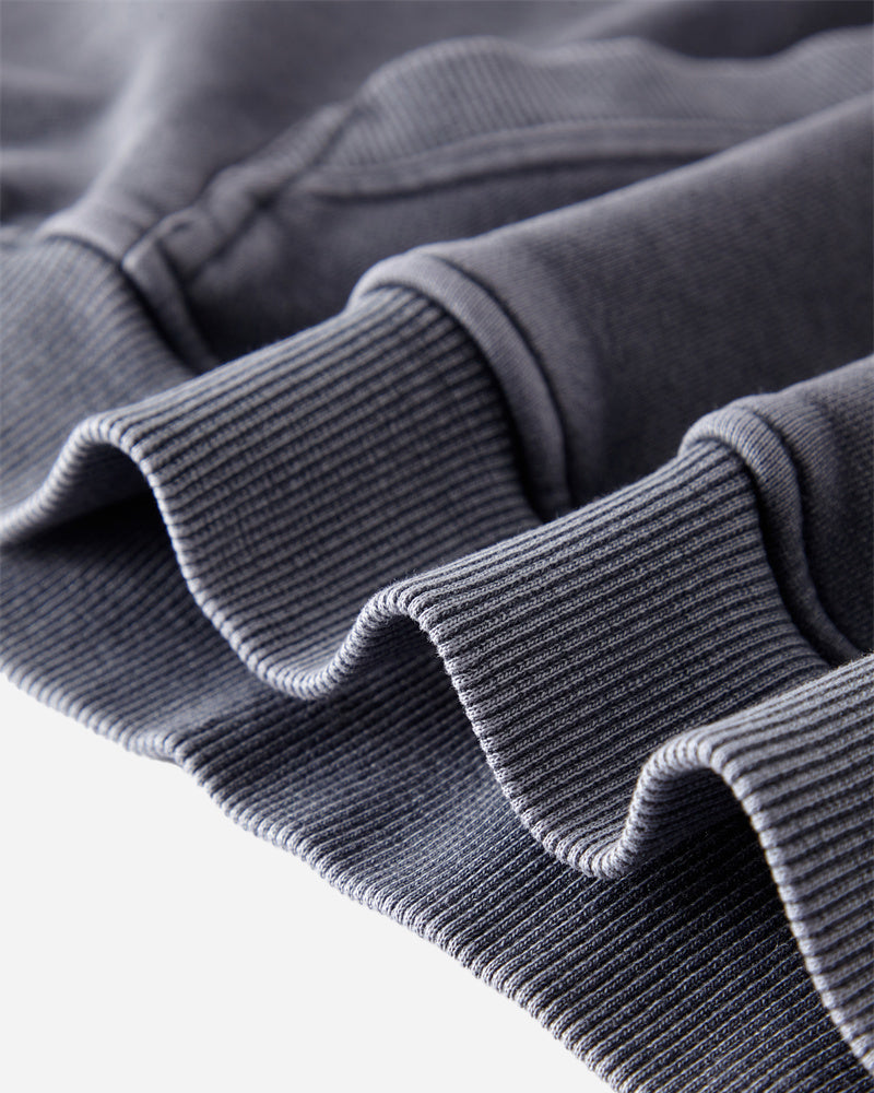 Bottom hem detail of the Heavy Hoodie in Washed Blue, highlighting the reinforced stitching and clean finish.